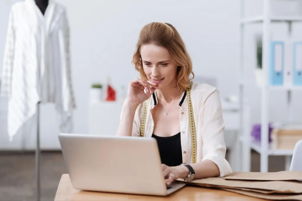 Dise&ntilde;o asistido por computadora: mujer con un ordenador en un taller de moda