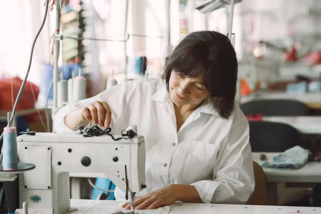 industria textil en el peru: mujer en una fabrica textil con una maquina de coser