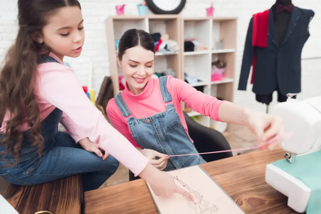 La proprietaria di un atelier di moda per bambini e una bambina che controlla le misure di un tessuto.