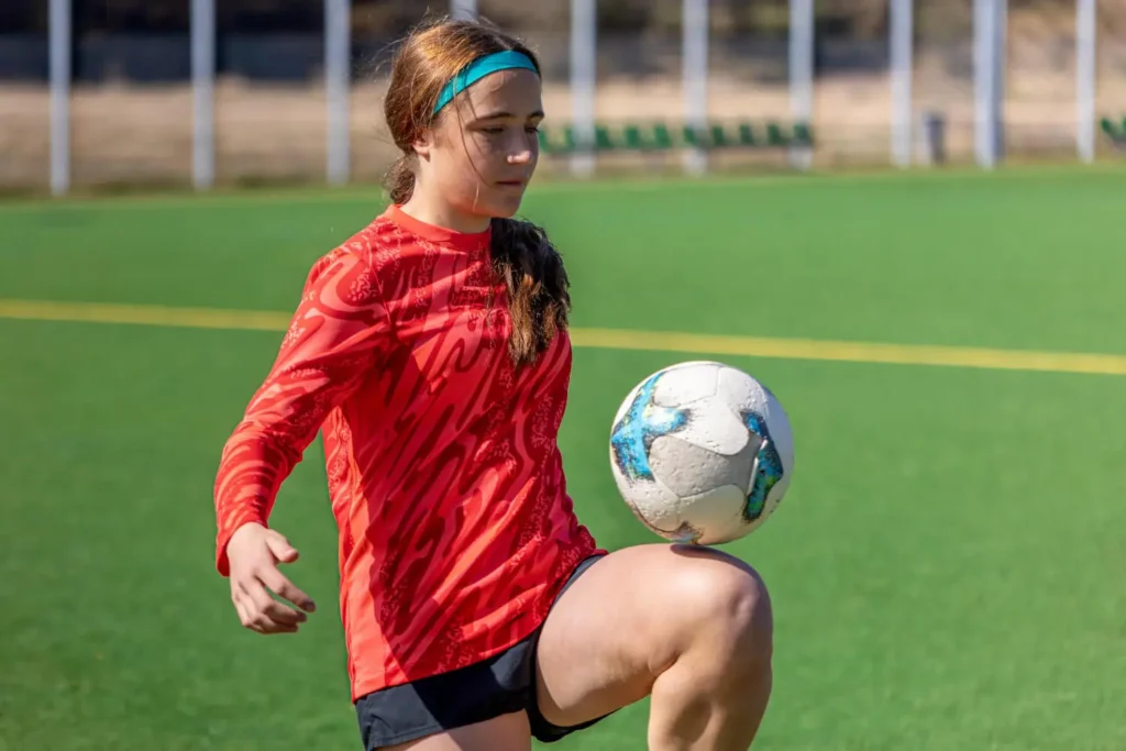 uniformes deportivos: mujer jugando al f&uacute;tbol